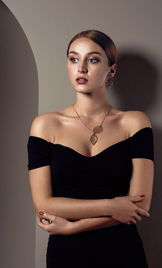 Girl wearing off shoulders dress and leaves shape golden necklace