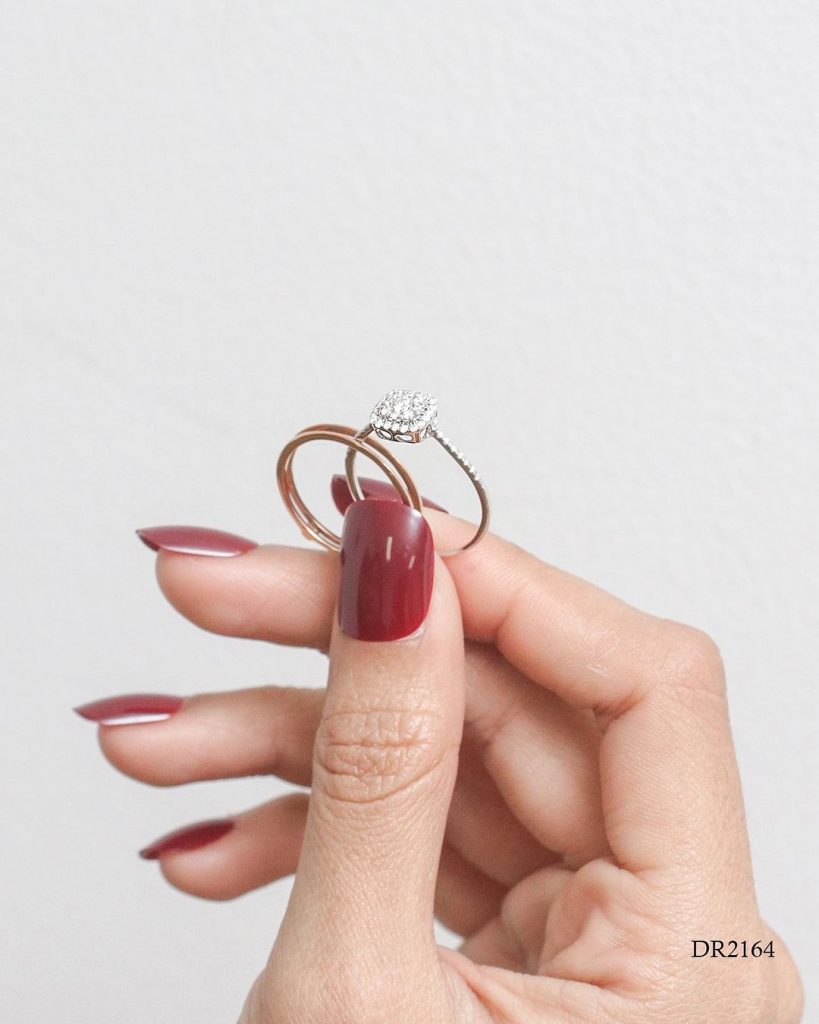 wanita memegang Cincin berlian stacked dengan jari